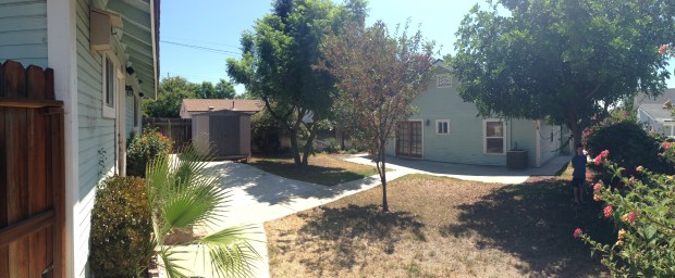 Backyard view of house and garage from the West corner. 