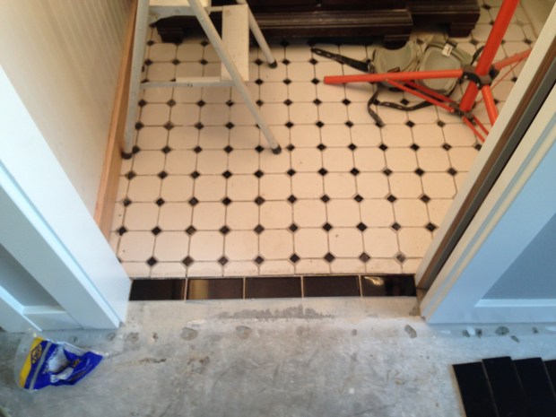 Black subway tiled used to transition between the existing bathroom tile and new carpet. 