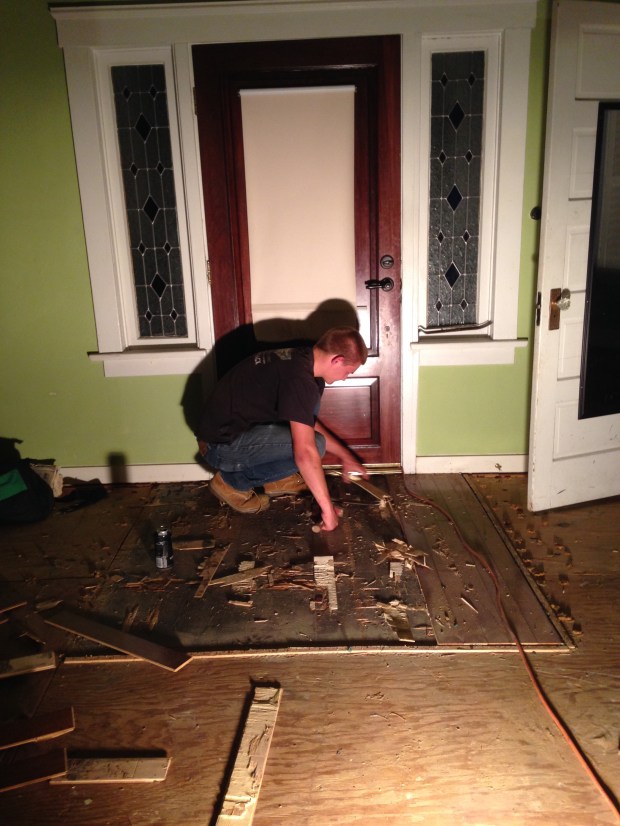 Jason removing the subfloor in the living room. 